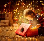 Kind öffnet Geschenke an Weihnachten