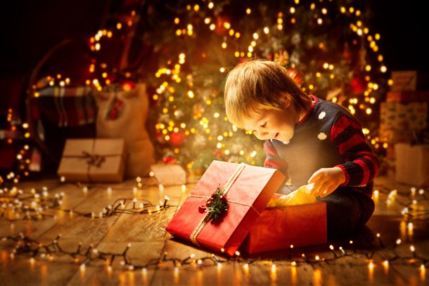 Kind öffnet Geschenke an Weihnachten