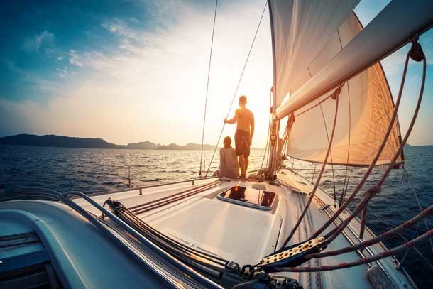 Pärchen schaut in den Sonnenuntergang auf einer Yacht.