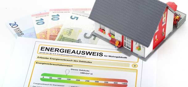 Zu sehen sind ein Energieausweisformular, Geldscheine und ein Modellhaus